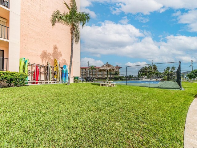 exterior space with a lawn and tennis court