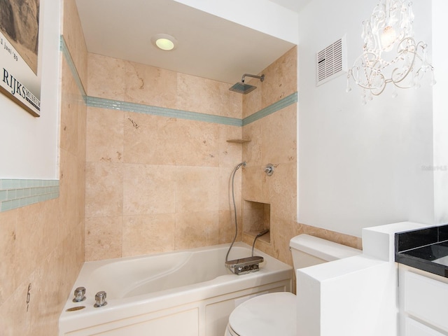 full bathroom with vanity, tiled shower / bath combo, and toilet