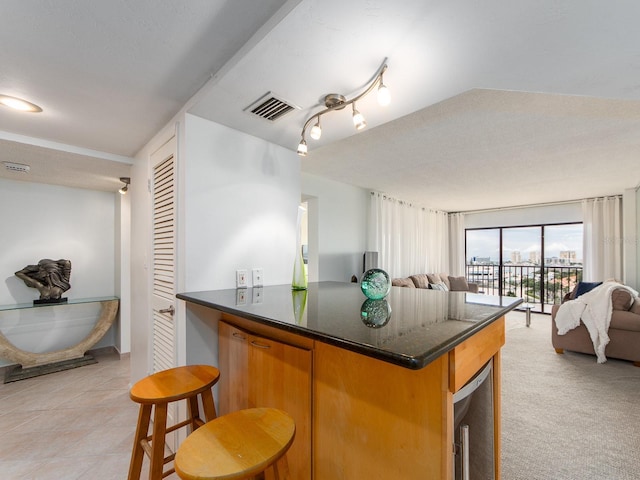 kitchen featuring wine cooler, light colored carpet, and kitchen peninsula