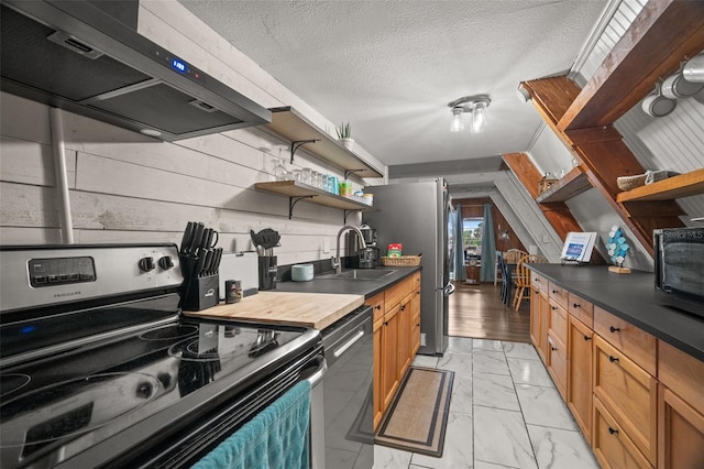 kitchen with sink, appliances with stainless steel finishes, a textured ceiling, and extractor fan