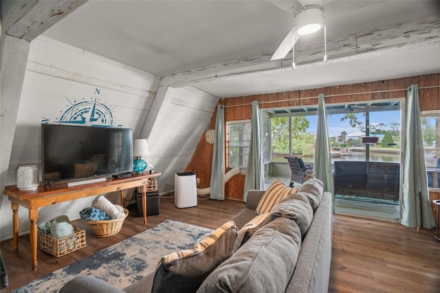 living room featuring hardwood / wood-style floors, wooden walls, vaulted ceiling, and ceiling fan