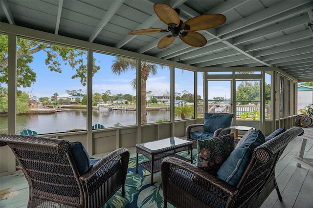 sunroom / solarium featuring a water view, ceiling fan, and beamed ceiling