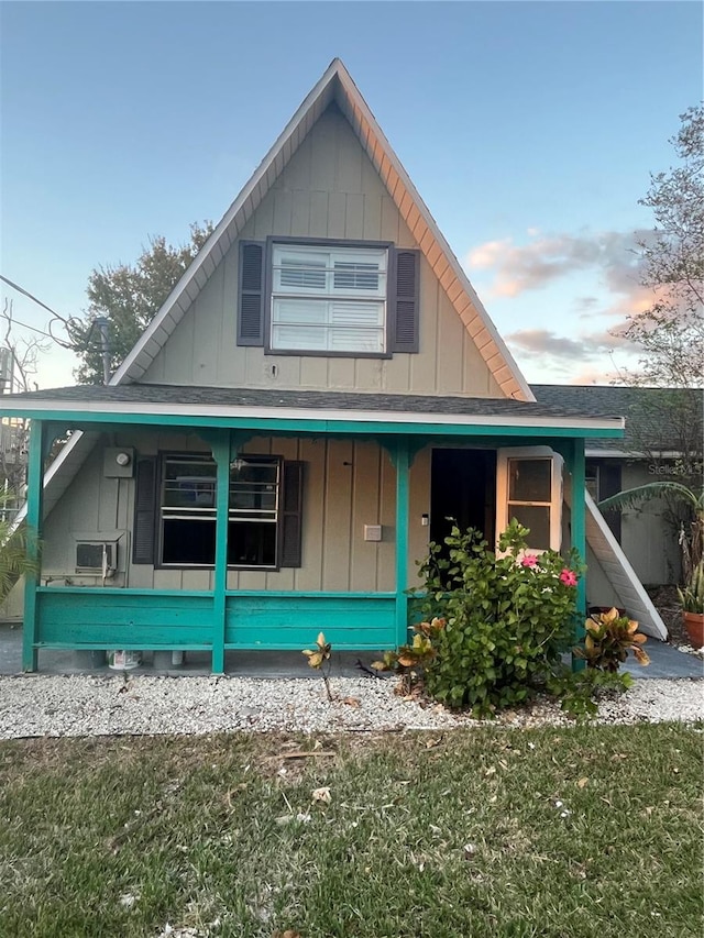 view of front of house featuring covered porch and a front lawn