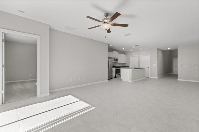 unfurnished living room with sink and ceiling fan