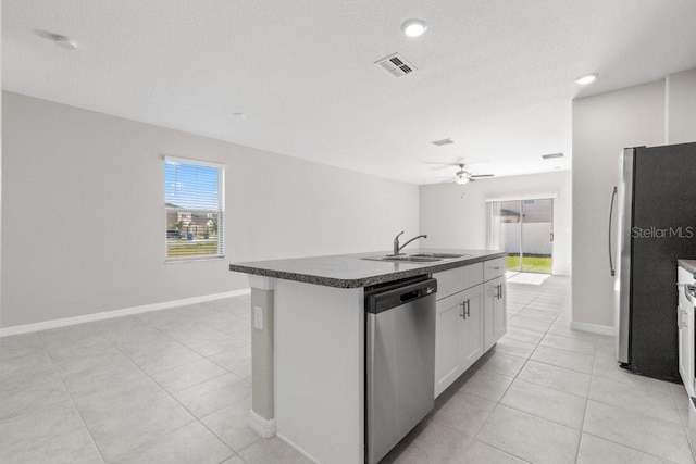 kitchen featuring an island with sink, stainless steel appliances, sink, ceiling fan, and white cabinets