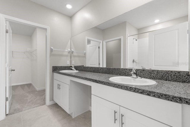 bathroom featuring tile patterned flooring, vanity, and a shower