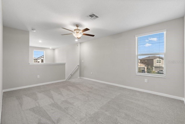 carpeted empty room featuring ceiling fan