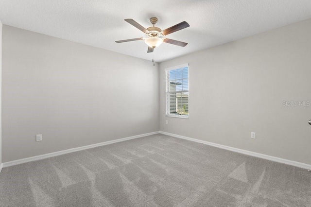 carpeted spare room featuring a textured ceiling and ceiling fan