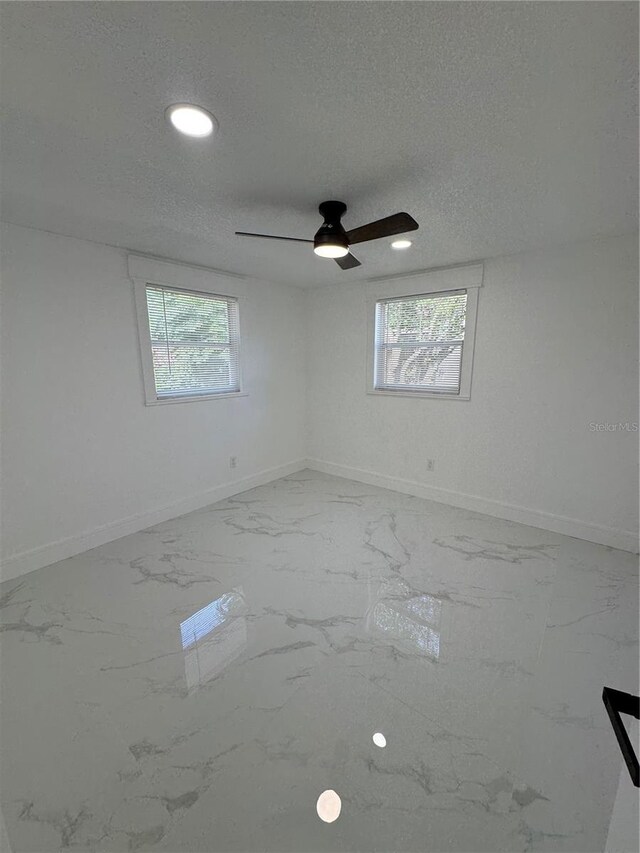 spare room with ceiling fan and a textured ceiling