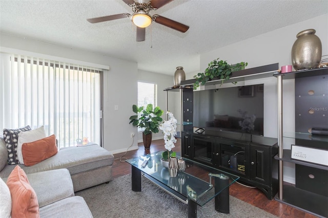 living room with ceiling fan, dark hardwood / wood-style flooring, and a textured ceiling