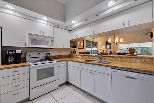 kitchen featuring white appliances, pendant lighting, light tile patterned floors, sink, and white cabinets