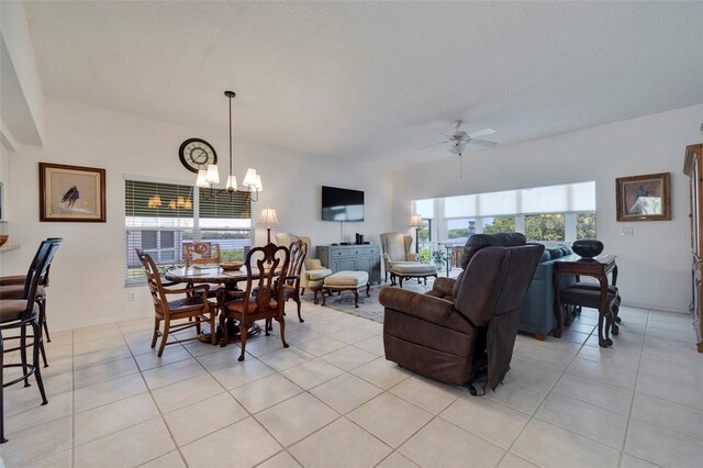 dining room featuring ceiling fan with notable chandelier and light tile patterned flooring