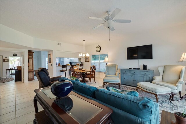 tiled living room with ceiling fan with notable chandelier, a textured ceiling, and a wealth of natural light