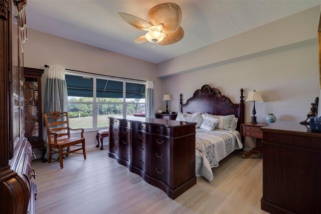 bedroom featuring a textured ceiling, light hardwood / wood-style flooring, and ceiling fan