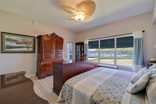 bedroom with light wood-type flooring, ceiling fan, and a textured ceiling