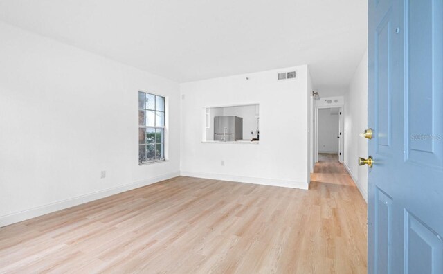 unfurnished room with light wood-type flooring