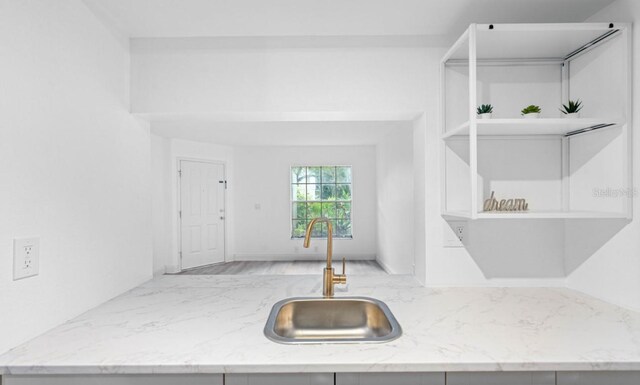 kitchen featuring light stone countertops and sink