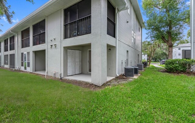 rear view of property featuring cooling unit and a yard