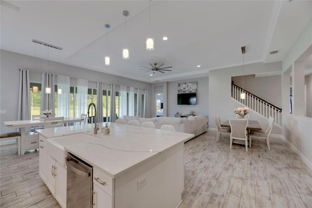 kitchen featuring pendant lighting, plenty of natural light, an island with sink, and stainless steel dishwasher