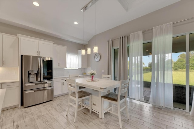 kitchen with white cabinets, plenty of natural light, and stainless steel refrigerator with ice dispenser