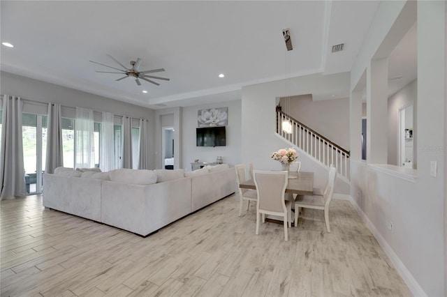 living room with ceiling fan, light hardwood / wood-style floors, and ornamental molding