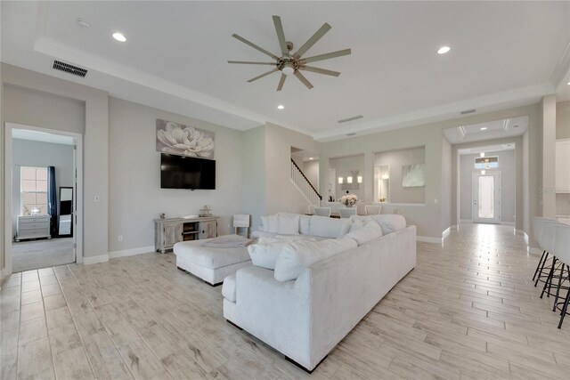 living room with a wealth of natural light, ceiling fan, ornamental molding, and light hardwood / wood-style floors