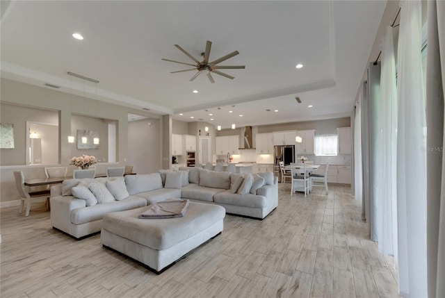 living room with crown molding, ceiling fan, and light hardwood / wood-style floors