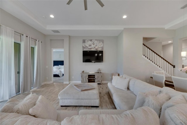 living room with light wood-type flooring, ceiling fan, and crown molding