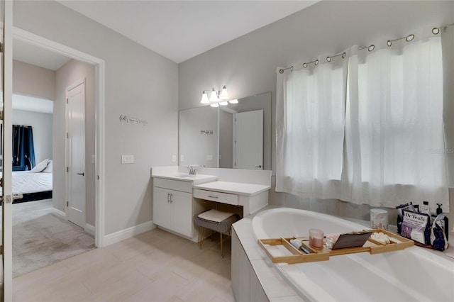 bathroom featuring tiled tub and vanity