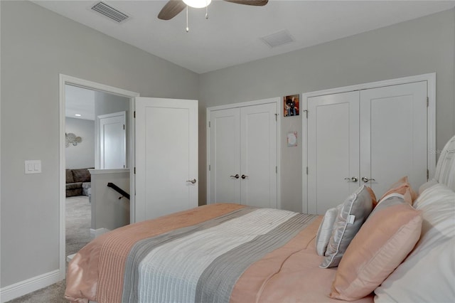 carpeted bedroom with multiple closets and ceiling fan