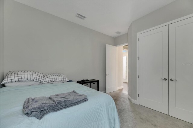 bedroom featuring light carpet and a closet