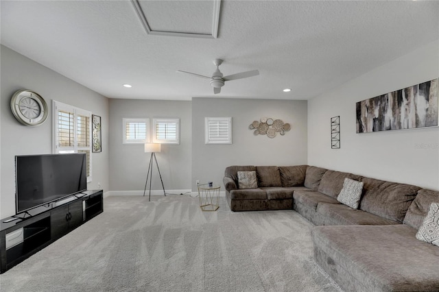 carpeted living room with ceiling fan and a textured ceiling