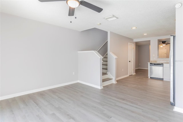 unfurnished living room featuring light wood-type flooring, a textured ceiling, and ceiling fan