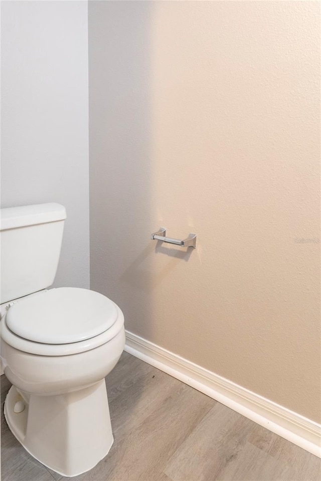 bathroom with hardwood / wood-style floors and toilet