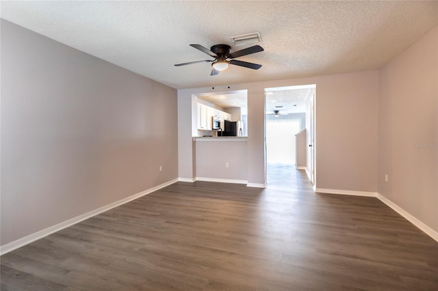 unfurnished living room featuring ceiling fan, dark wood-type flooring, and a textured ceiling