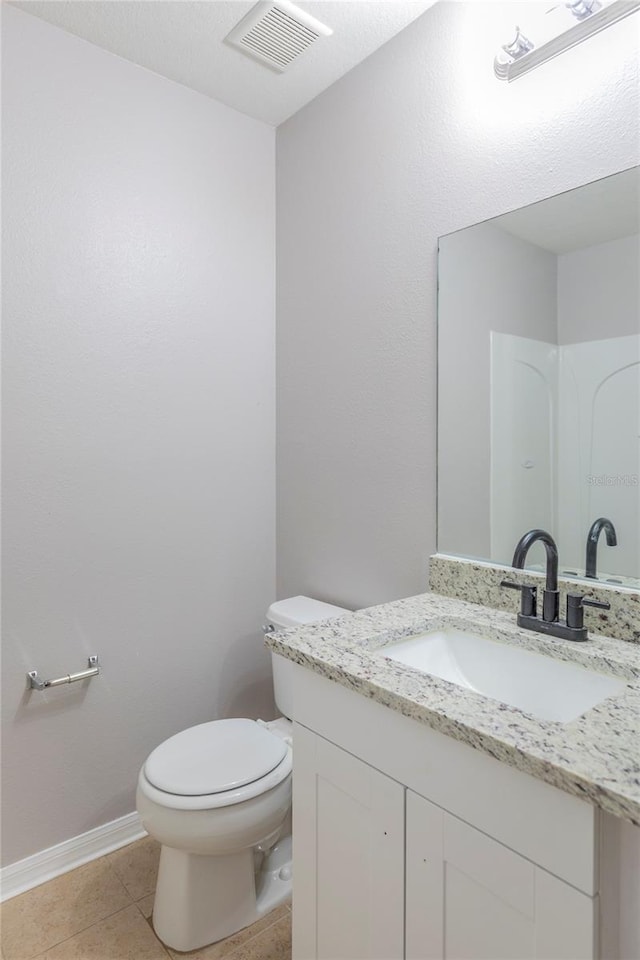 bathroom featuring tile patterned floors, vanity, and toilet