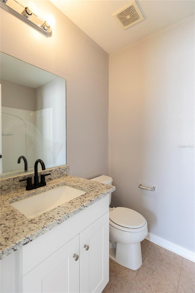 bathroom with vanity, toilet, and tile patterned floors