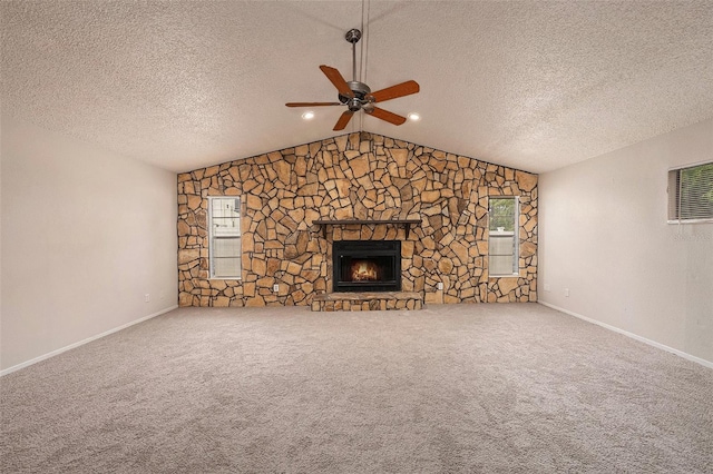 unfurnished living room featuring ceiling fan, a textured ceiling, a fireplace, and carpet flooring