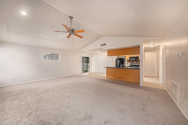 unfurnished living room featuring ceiling fan, a textured ceiling, light carpet, and vaulted ceiling