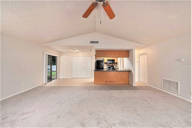 unfurnished living room with light carpet, a textured ceiling, vaulted ceiling, and ceiling fan