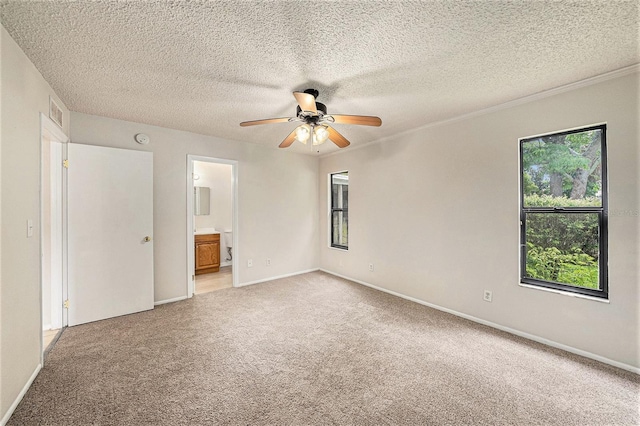 unfurnished bedroom with connected bathroom, ceiling fan, light colored carpet, and a textured ceiling