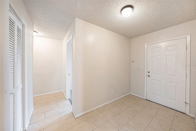 tiled entryway featuring a textured ceiling