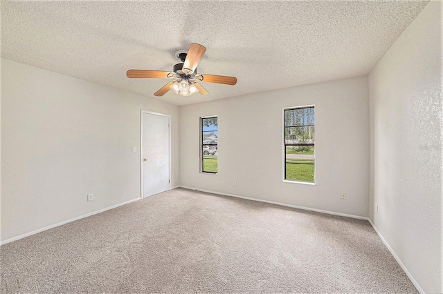 carpeted spare room with a textured ceiling and ceiling fan