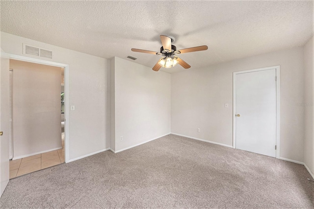 carpeted empty room featuring a textured ceiling and ceiling fan