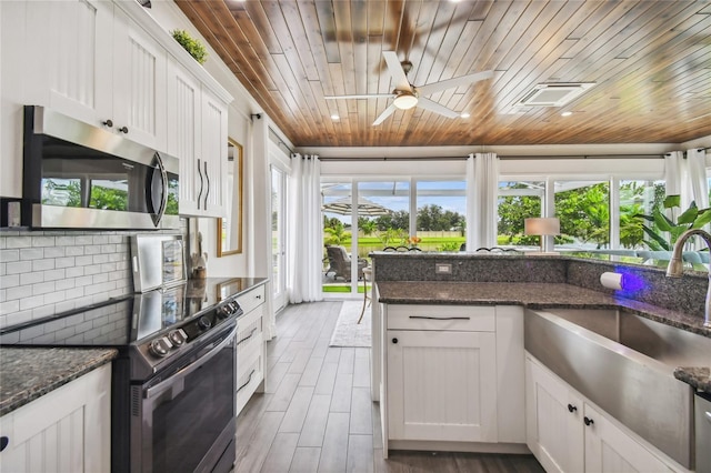 kitchen featuring ceiling fan, appliances with stainless steel finishes, wood ceiling, and white cabinetry