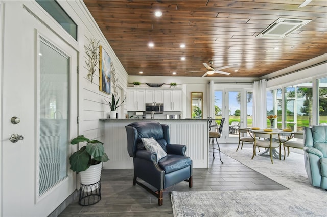 sunroom / solarium featuring ceiling fan, wooden ceiling, and french doors