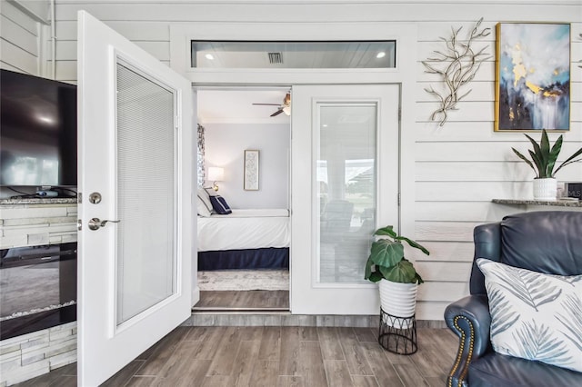 bedroom with crown molding, wood walls, and hardwood / wood-style flooring