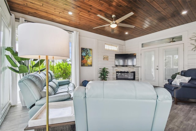 living room featuring ceiling fan, wood ceiling, and plenty of natural light