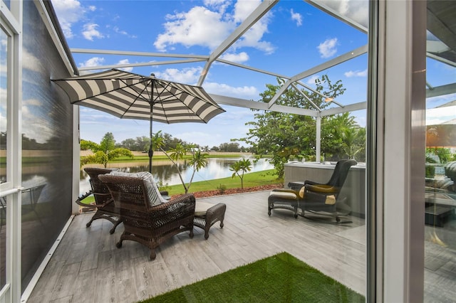 exterior space with glass enclosure and a water view