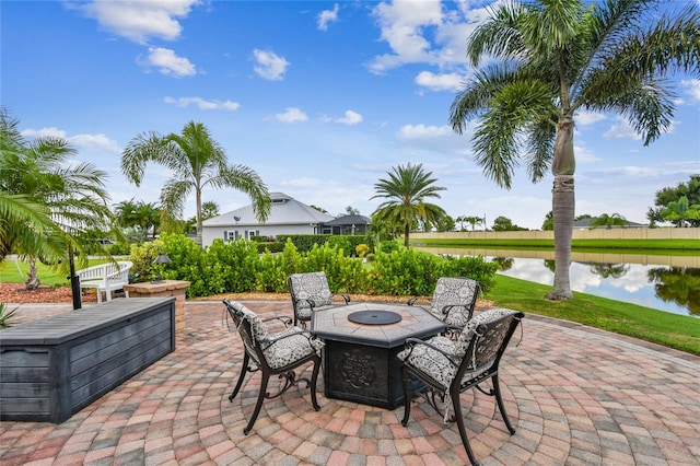 view of patio with a water view and a fire pit